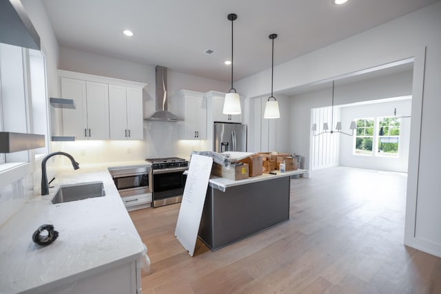 4072 Penfield Dr Unit B, Franklin, TN 37069 - kitchen with appliances with stainless steel finishes, wall chimney range hood, a kitchen island, white cabinetry, and light wood-style flooring