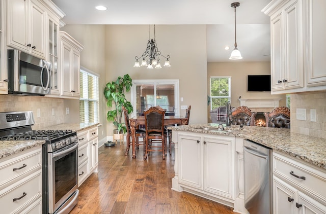 813 Stone Mill Cir, Murfreesboro, TN 37130 - kitchen featuring stainless steel appliances, a sink, a peninsula, light wood finished floors, and plenty of natural light