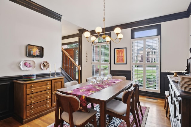 6781 Autumnwood Dr, Nashville, TN 37221 - dining space with a chandelier, a wainscoted wall, ornamental molding, stairs, and light wood finished floors