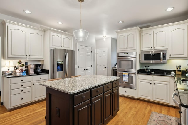 6781 Autumnwood Dr, Nashville, TN 37221 - kitchen with appliances with stainless steel finishes, white cabinets, pendant lighting, dark brown cabinets, and light wood finished floors