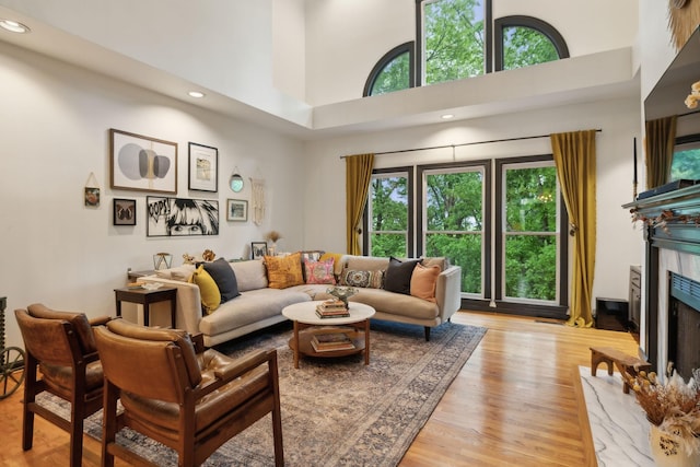 6781 Autumnwood Dr, Nashville, TN 37221 - living room with a high ceiling, a premium fireplace, light wood-style floors, and recessed lighting