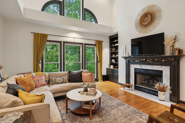 6781 Autumnwood Dr, Nashville, TN 37221 - living area with wood finished floors, built in features, a fireplace, and a high ceiling