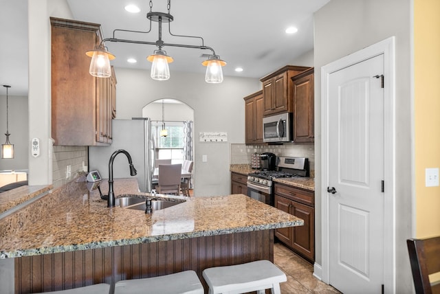 2157 Christina Ct, Hermitage, TN 37076 - kitchen with stainless steel appliances, a peninsula, a sink, light stone countertops, and tasteful backsplash