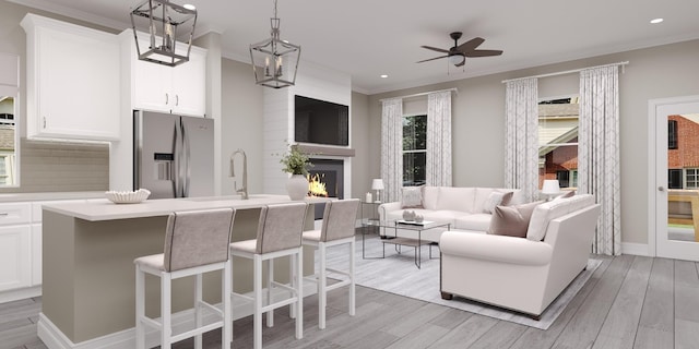 1779 Kemp Dr, Hermitage, TN 37076 - kitchen with stainless steel fridge with ice dispenser, ornamental molding, a sink, open floor plan, and a warm lit fireplace
