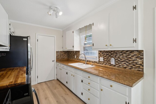 510 Bismark Dr, Nashville, TN 37210 - kitchen featuring a sink, ornamental molding, light wood finished floors, decorative backsplash, and white cabinets