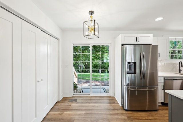 304 Jenny Murff Dr, Antioch, TN 37013 - kitchen with stainless steel appliances, light countertops, a chandelier, backsplash, and light wood-style floors