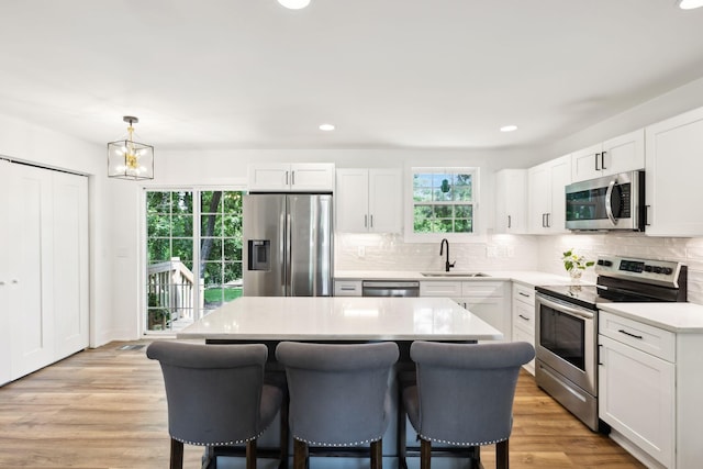 304 Jenny Murff Dr, Antioch, TN 37013 - kitchen featuring appliances with stainless steel finishes, a sink, a breakfast bar area, plenty of natural light, and recessed lighting