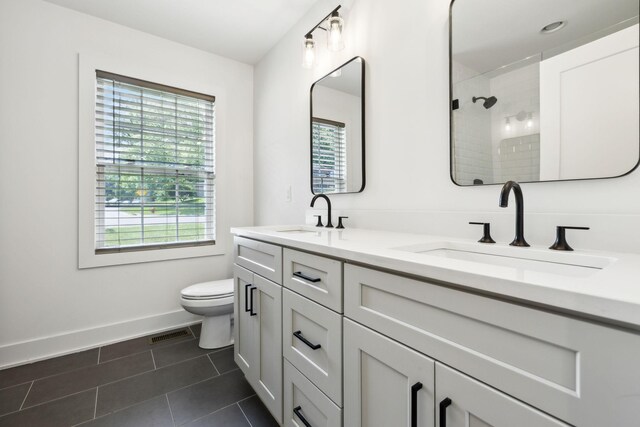 304 Jenny Murff Dr, Antioch, TN 37013 - bathroom featuring tile patterned floors, double vanity, toilet, baseboards, and tiled shower