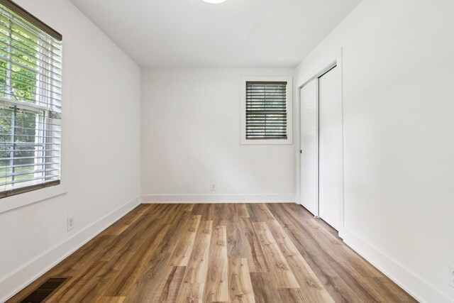 304 Jenny Murff Dr, Antioch, TN 37013 - unfurnished bedroom featuring multiple windows, wood finished floors, a closet, and baseboards