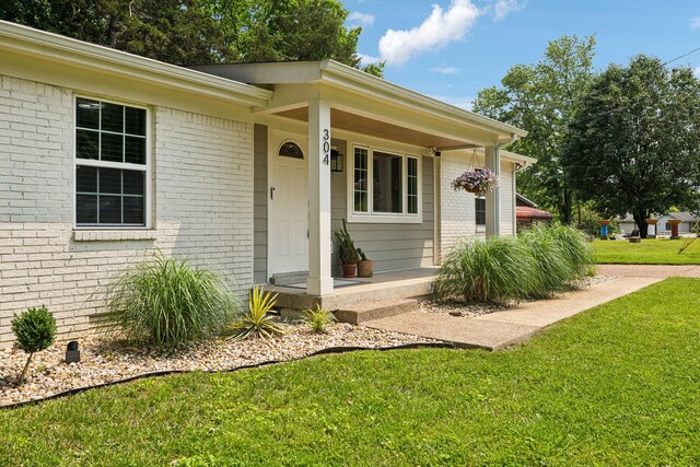 304 Jenny Murff Dr, Antioch, TN 37013 - view of exterior entry with brick siding, a lawn, and covered porch