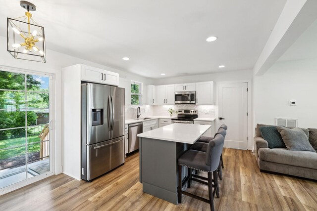 304 Jenny Murff Dr, Antioch, TN 37013 - kitchen featuring stainless steel appliances, light countertops, a kitchen bar, backsplash, and white cabinetry