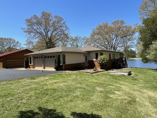 464 Loop Dr, Winchester, TN 37398 - view of front of home featuring an attached garage, driveway, a front lawn, and a water view