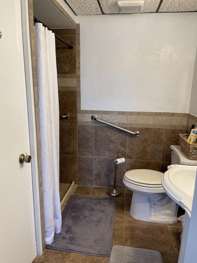 464 Loop Dr, Winchester, TN 37398 - bathroom featuring a shower stall, toilet, tile walls, wainscoting, and a sink