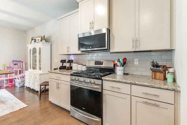 6531 Tulip Tree Dr, Murfreesboro, TN 37128 - kitchen with appliances with stainless steel finishes, decorative backsplash, light wood-type flooring, white cabinets, and light stone counters