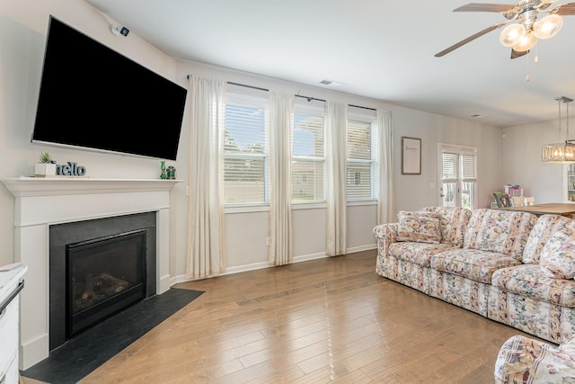 6531 Tulip Tree Dr, Murfreesboro, TN 37128 - living room featuring a ceiling fan, wood finished floors, a fireplace with flush hearth, and baseboards