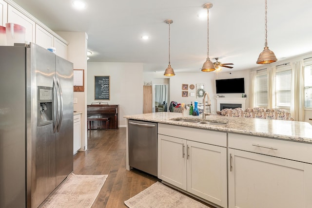 6531 Tulip Tree Dr, Murfreesboro, TN 37128 - kitchen featuring appliances with stainless steel finishes, a sink, a ceiling fan, white cabinets, and a fireplace