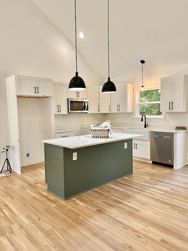 5702 Little Dry Creek Rd, Pulaski, TN 38478 - kitchen with stainless steel appliances, a sink, light wood-style floors, a center island, and hanging light fixtures