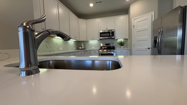 881 Meadowcrest Way, Lebanon, TN 37090 - kitchen with stainless steel appliances, backsplash, white cabinetry, light countertops, and recessed lighting