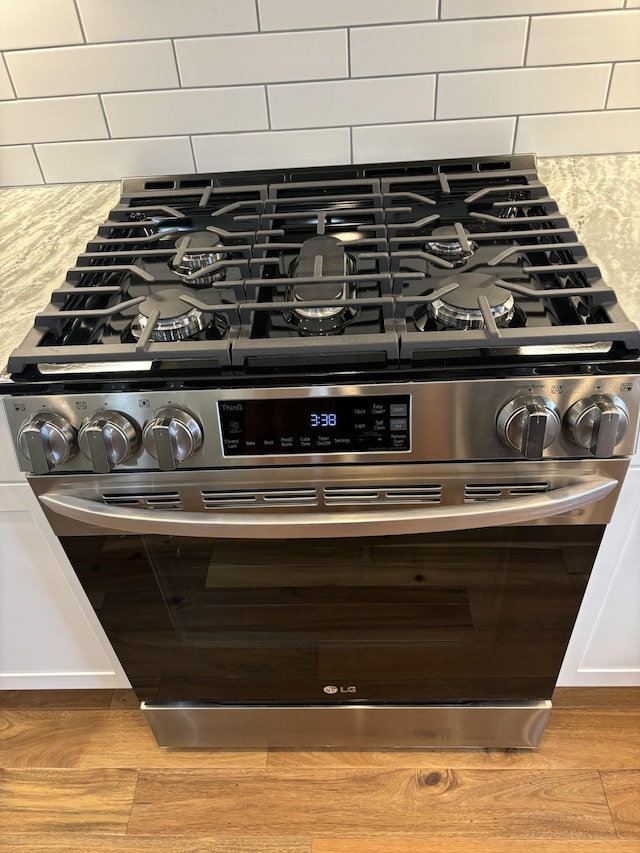 2420 Eagle Rock Rd, Monteagle, TN 37356 - kitchen view of gas stove, wood finished floors, light countertops, and backsplash