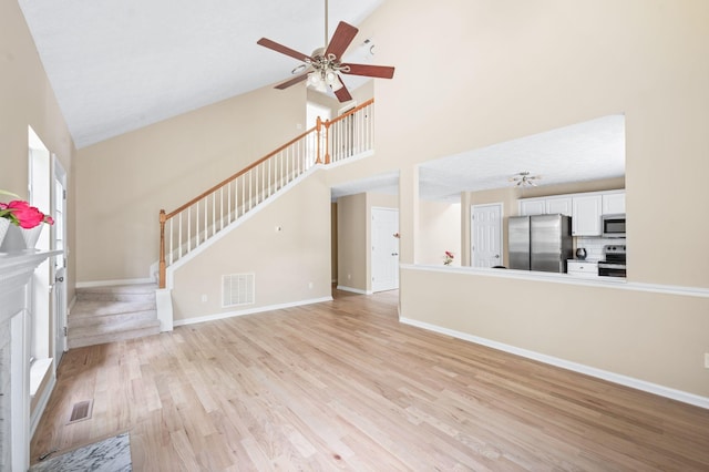2210 Falcon Creek Dr, Franklin, TN 37067 - unfurnished living room with high vaulted ceiling, a ceiling fan, light wood-style flooring, baseboards, and stairway