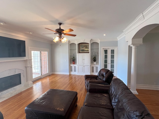 6464 Lebanon Rd, Murfreesboro, TN 37129 - living room with arched walkways, light wood-type flooring, a fireplace, decorative columns, and a ceiling fan