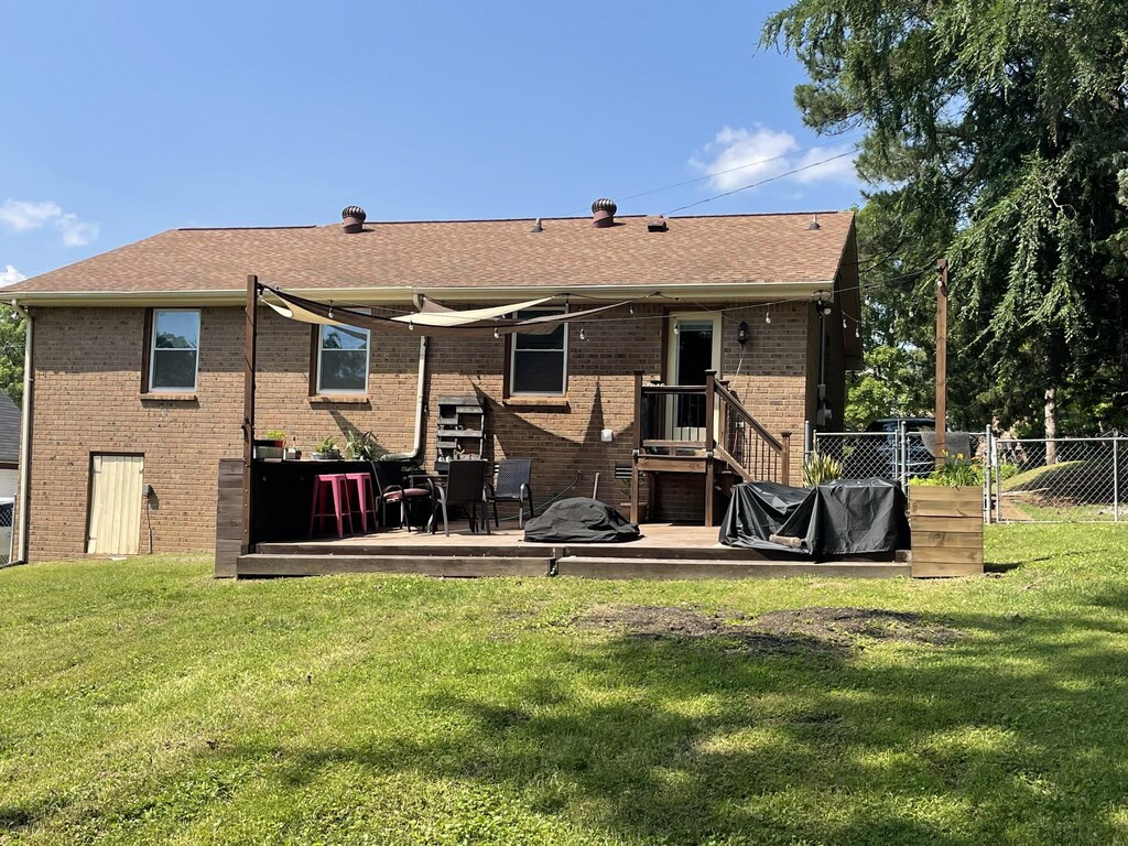 3309 Cedar Ridge Rd, Nashville, TN 37214 - rear view of property featuring a deck, brick siding, and a shingled roof