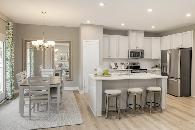 1171 Savannah Ave, Gallatin, TN 37066 - kitchen featuring appliances with stainless steel finishes, a sink, a chandelier, light wood-style flooring, and light countertops