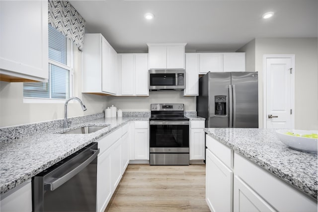 1296 Laurel St, Gallatin, TN 37066 - kitchen with stainless steel appliances, a sink, light wood-style floors, white cabinets, and recessed lighting