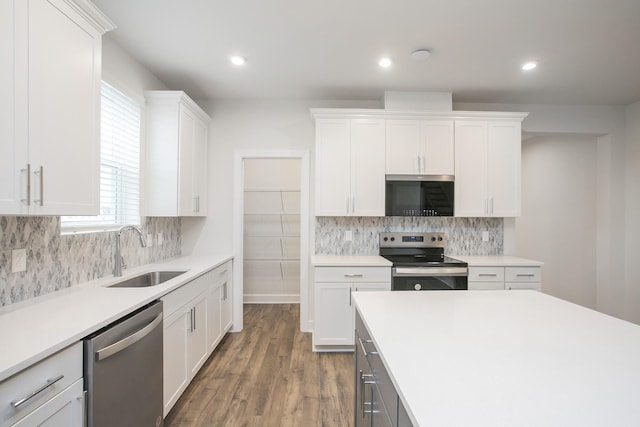 3013 Kemp Dr, Hermitage, TN 37076 - kitchen featuring stainless steel appliances, a sink, light countertops, white cabinets, and wood finished floors