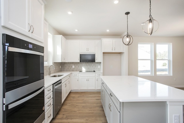 3263 Kemp Dr, Hermitage, TN 37076 - kitchen featuring black appliances, a sink, a center island, backsplash, and white cabinetry