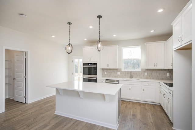 3263 Kemp Dr, Hermitage, TN 37076 - kitchen with stainless steel appliances, decorative backsplash, a sink, a center island, and wood finished floors