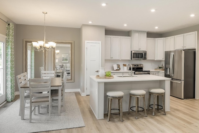 1173 Savannah Ave, Gallatin, TN 37066 - kitchen featuring appliances with stainless steel finishes, a sink, a chandelier, light wood-type flooring, and light countertops