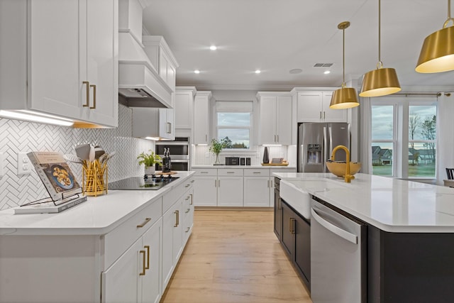 2521 Kingston Ct, Mount Juliet, TN 37122 - kitchen featuring appliances with stainless steel finishes, premium range hood, a center island with sink, light countertops, and light wood-style floors