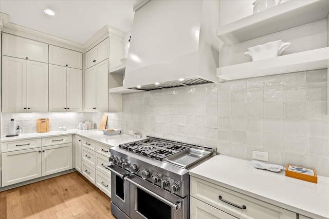1750 Barrow Ln, Brentwood, TN 37027 - kitchen with range with two ovens, wall chimney exhaust hood, backsplash, light countertops, and recessed lighting