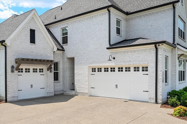 1750 Barrow Ln, Brentwood, TN 37027 - view of side of home featuring concrete driveway, a garage, brick siding, and roof with shingles