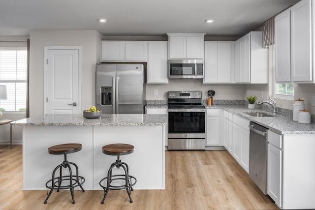 1553 Thornton Grove Blvd, Nashville, TN 37207 - kitchen featuring stainless steel appliances, a sink, a kitchen island, light wood-style flooring, and white cabinets