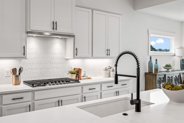 1005 Cherry Tree Dr, Mount Juliet, TN 37122 - kitchen with stainless steel gas stovetop, a sink, tasteful backsplash, white cabinets, and light countertops