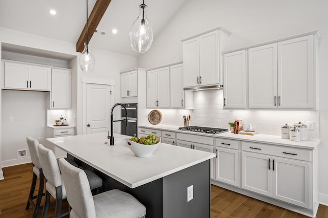 1005 Cherry Tree Dr, Mount Juliet, TN 37122 - kitchen featuring stainless steel gas stovetop, tasteful backsplash, white cabinets, an island with sink, and dark wood-type flooring