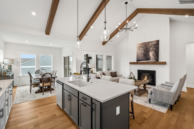 1005 Cherry Tree Dr, Mount Juliet, TN 37122 - kitchen featuring open floor plan, a sink, stainless steel dishwasher, a glass covered fireplace, and beamed ceiling