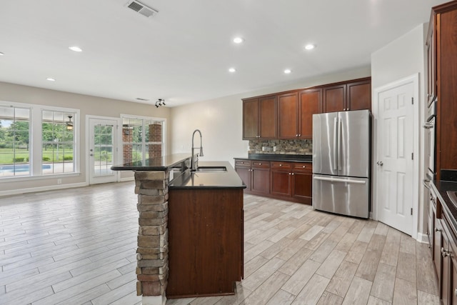 102 Oglethorpe Ave, Gallatin, TN 37066 - kitchen with freestanding refrigerator, a sink, dark countertops, light wood-style floors, and tasteful backsplash