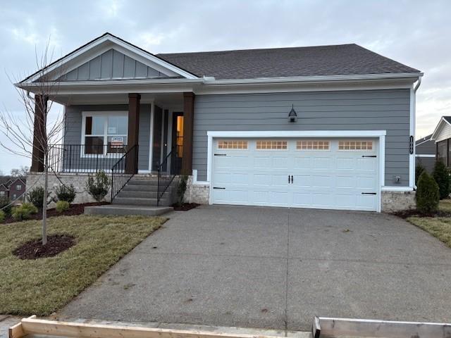 1320 Ashton Park Dr, Mount Juliet, TN 37122 - view of front facade with driveway, a porch, a garage, and stone siding