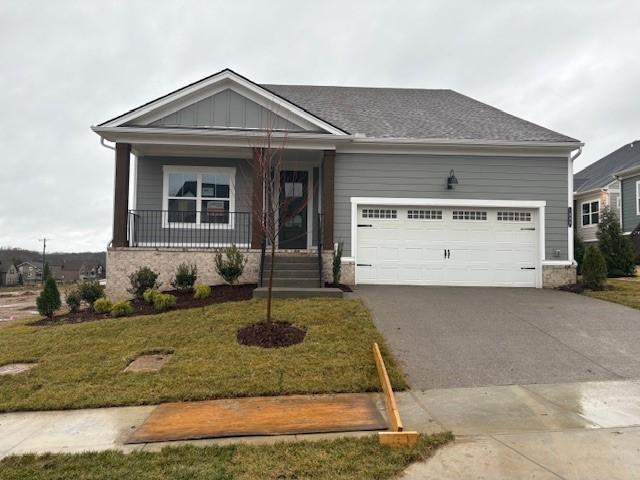 1320 Ashton Park Dr, Mount Juliet, TN 37122 - ranch-style house featuring driveway, an attached garage, a front lawn, a porch, and board and batten siding