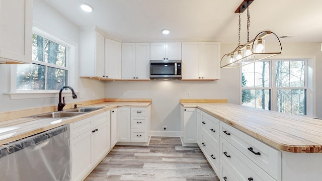 9716 Campbellsville Rd, Pulaski, TN 38478 - kitchen with appliances with stainless steel finishes, a sink, light wood-style flooring, a peninsula, and white cabinets