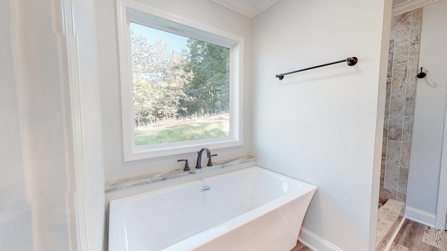 9716 Campbellsville Rd, Pulaski, TN 38478 - bathroom featuring healthy amount of natural light, a garden tub, tiled shower, ornamental molding, and wood finished floors