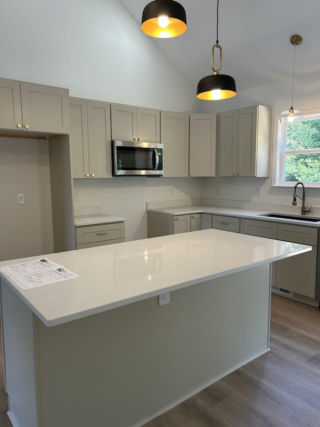 9710 Campbellsville Rd, Pulaski, TN 38478 - kitchen featuring stainless steel microwave, gray cabinets, a sink, dark wood-style floors, and decorative light fixtures