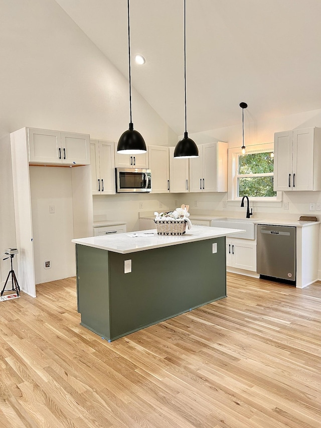 9710 Campbellsville Rd, Pulaski, TN 38478 - kitchen featuring appliances with stainless steel finishes, a sink, light wood-style floors, a kitchen island, and hanging light fixtures