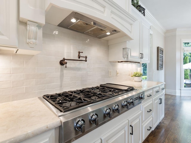 5007 Buds Farm Ln, Franklin, TN 37064 - kitchen with stainless steel gas cooktop, wall chimney exhaust hood, white cabinets, decorative backsplash, and ornamental molding