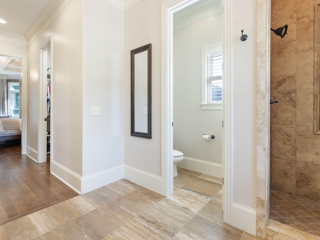5007 Buds Farm Ln, Franklin, TN 37064 - bathroom featuring a tile shower, crown molding, plenty of natural light, toilet, and baseboards