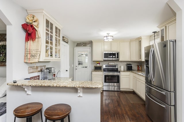 102 Ryburn Dr, Old Hickory, TN 37138 - kitchen with stainless steel appliances, cream cabinetry, a peninsula, and light stone countertops