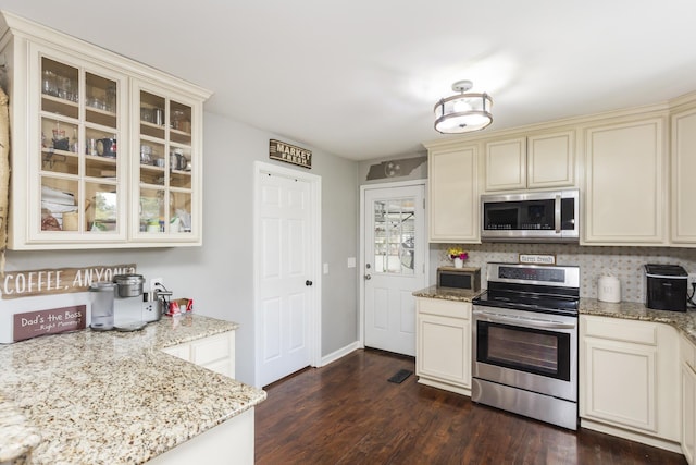 102 Ryburn Dr, Old Hickory, TN 37138 - kitchen featuring appliances with stainless steel finishes, cream cabinetry, light stone counters, glass insert cabinets, and dark wood-style floors